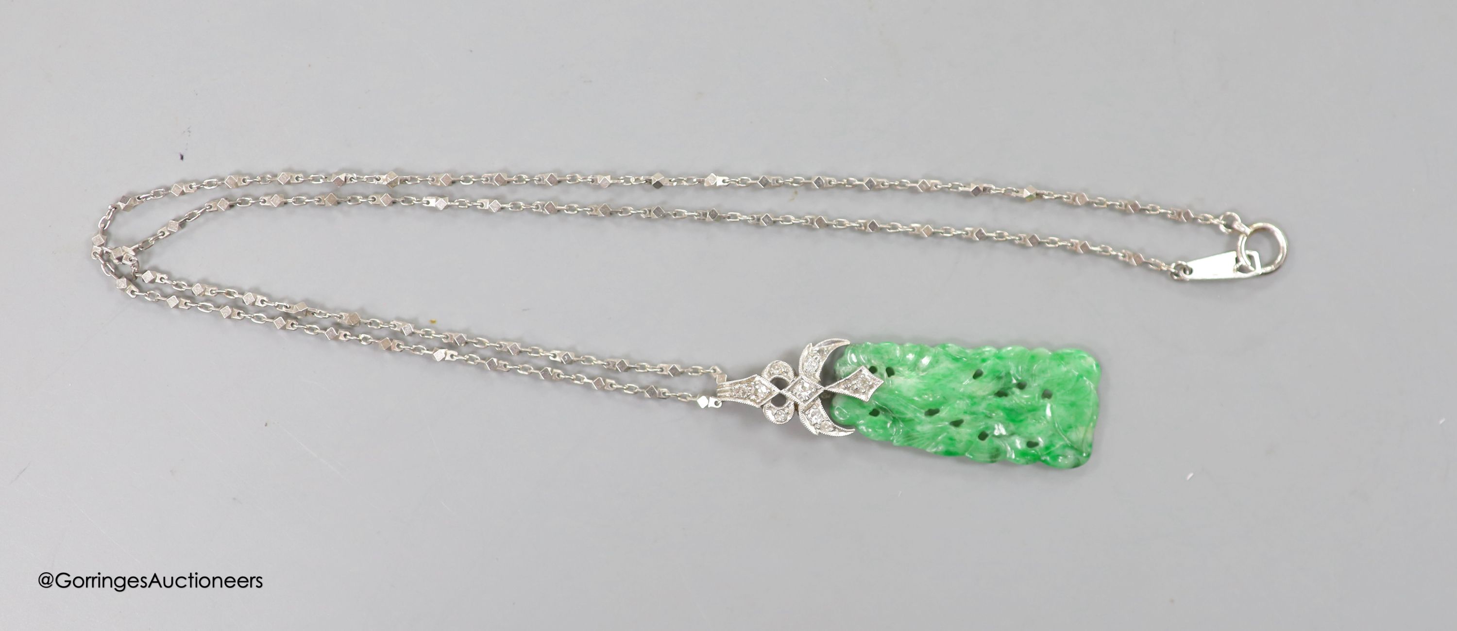 A 1920's white metal and diamond mounted carved jade pendant, numbered 'G 320 1', 4cm, on a platinum fancy link chain, 40cm, gross weight 7.6 grams